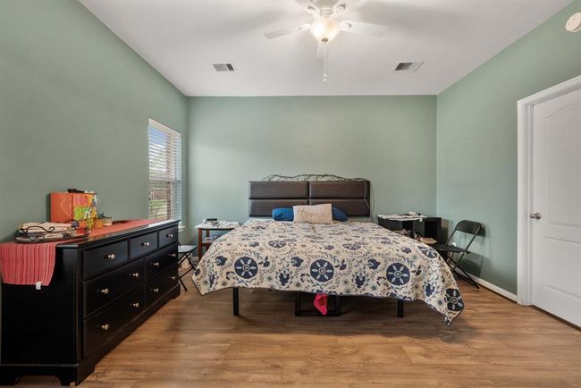 The primary bedroom has custom paint, large window, and a ceiling fan. | Image 15