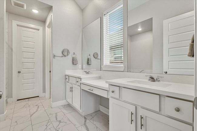 Bathroom featuring a sink, a healthy amount of sunlight, double vanity, and visible vents | Image 12