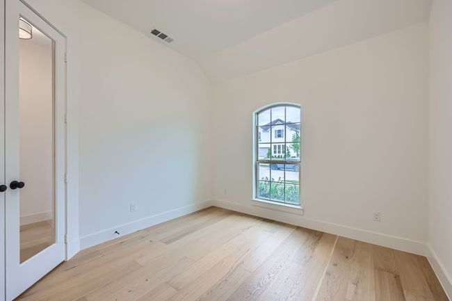 Spare room with vaulted ceiling, light wood-style floors, visible vents, and baseboards | Image 12