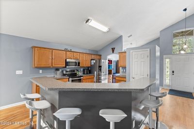 Kitchen with bar top that seats 6 and is open to the fmaily room. | Image 2