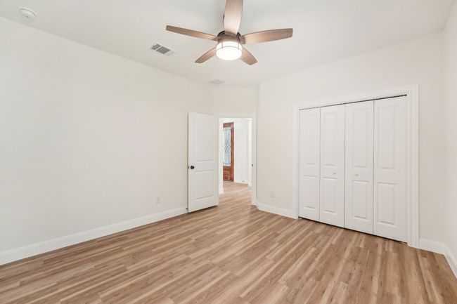 Bedroom 3 with visible vents, wood plank vinyl floor, a closet, baseboards, and ceiling fan | Image 31