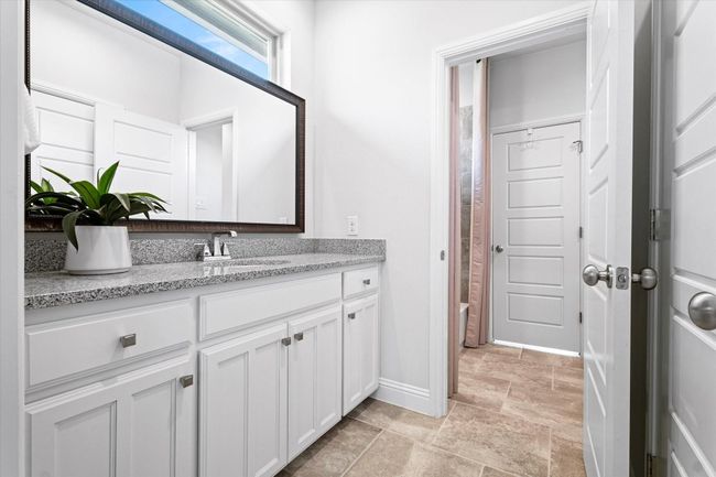 Full bathroom with vanity, stone finish floors, and shower / bathtub combination with curtain | Image 26