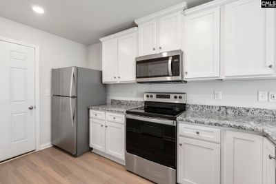 The kitchen features granite countertops and a full suite of stainless steel appliances. | Image 3