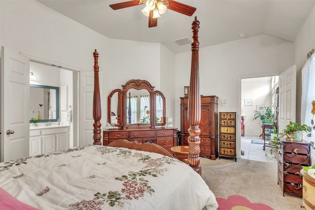 Carpeted bedroom with connected bathroom, vaulted ceiling, and ceiling fan | Image 23