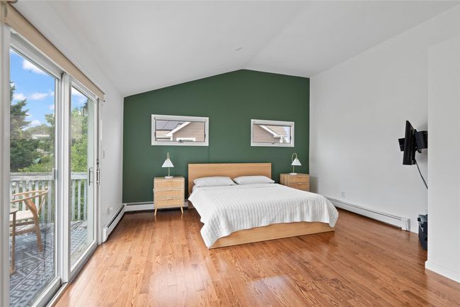 Full bath with a baseboard radiator, double vanity, wood finished floors, enclosed tub / shower combo, and recessed lighting | Image 25