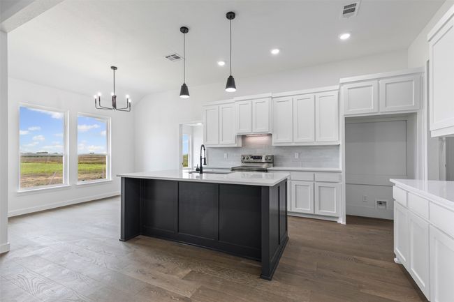 Kitchen with visible vents, a sink, stainless steel electric range, and a chandelier | Image 13