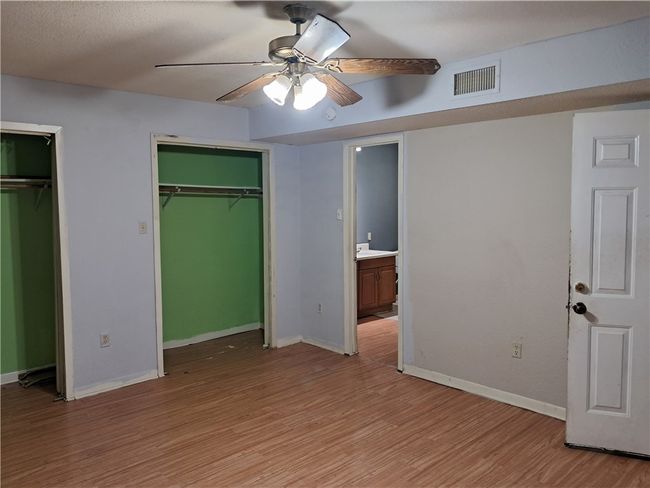 Unfurnished bedroom featuring multiple closets, light wood-type flooring, and ceiling fan | Image 5