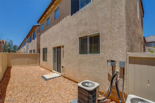 Back of property featuring a fenced backyard, stucco siding, and central AC unit | Image 25
