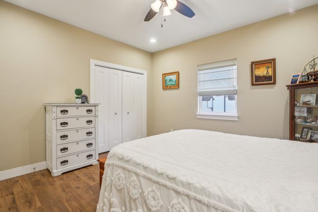 Bedroom with ceiling fan, dark hardwood / wood-style floors, and a closet | Image 22