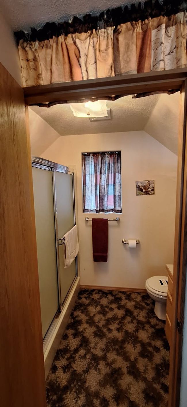 Loft Bathroom with a shower stall, toilet, vaulted ceiling, and baseboards | Image 31