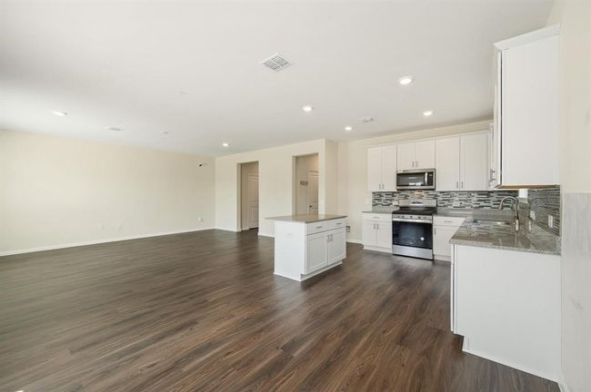 Granite kitchen opening to spacious living room | Image 10