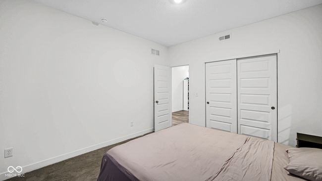 bedroom with baseboards, a closet, and dark colored carpet | Image 9