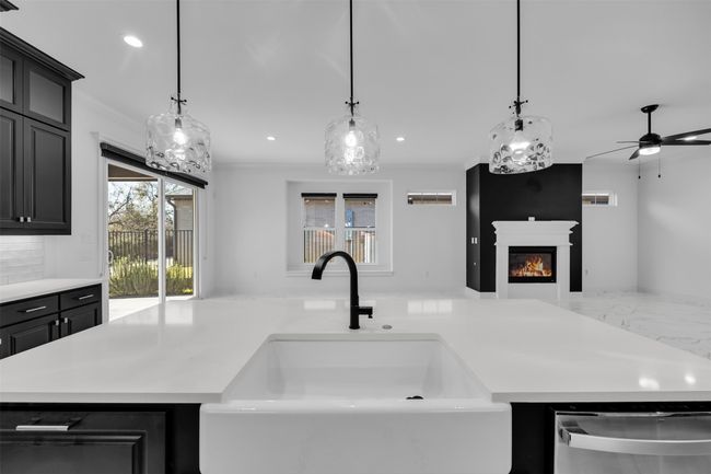 Kitchen with marble finish floor, open floor plan, light countertops, and a sink | Image 9