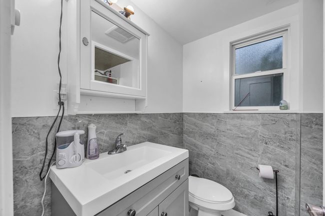 Bathroom featuring tile walls, vanity, and wainscoting | Image 24
