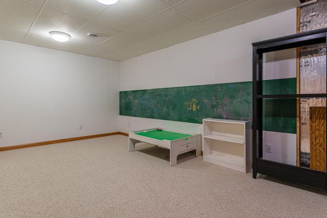Game room in lower level features a chalkboard wall. | Image 15