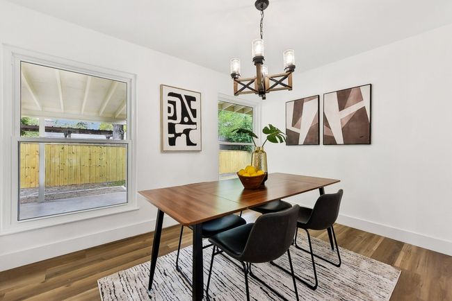 Dining area with an inviting chandelier, wood finished floors, and baseboards | Image 12