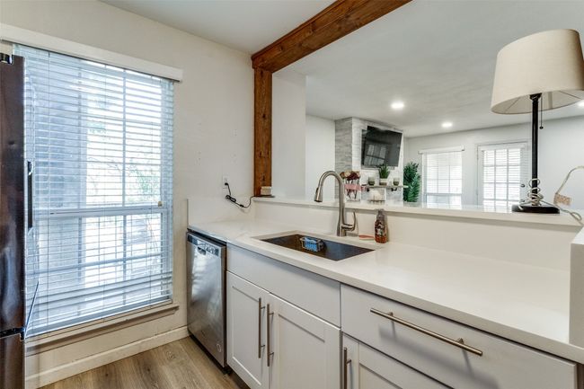 Kitchen featuring a sink, a wealth of natural light, light wood-type flooring, black fridge with ice dispenser, and dishwasher | Image 6
