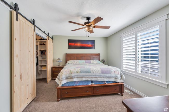 Bedroom with a barn door, carpet, a walk in closet, and a closet | Image 8
