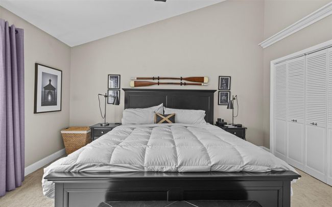 Bedroom with high vaulted ceiling, baseboards, light carpet, and a closet | Image 11