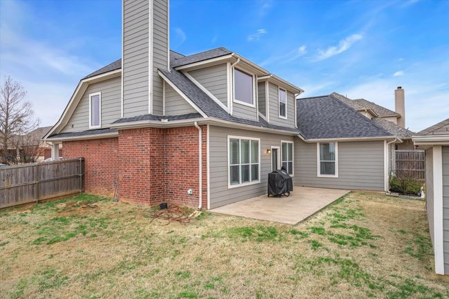 Rear view of property featuring a yard, a patio area, brick siding, and fence | Image 29