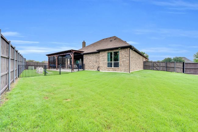 Back of house featuring a chimney, brick siding, and a shingled roof | Image 32