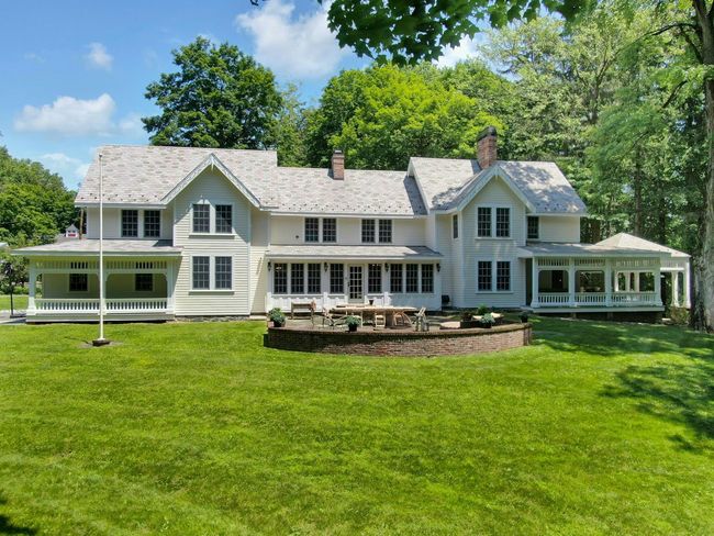 Back of property with a sunroom, a yard, and a chimney | Image 38