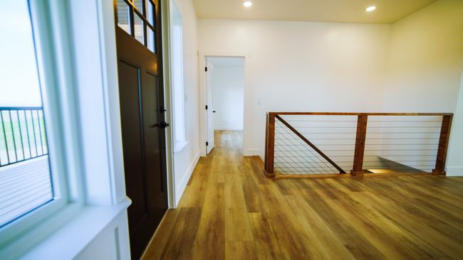 Hall with an upstairs landing, healthy amount of natural light, wood finished floors, and recessed lighting | Image 30