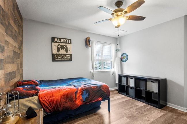 Bedroom with wood laminate floors, baseboards, and a ceiling fan | Image 24