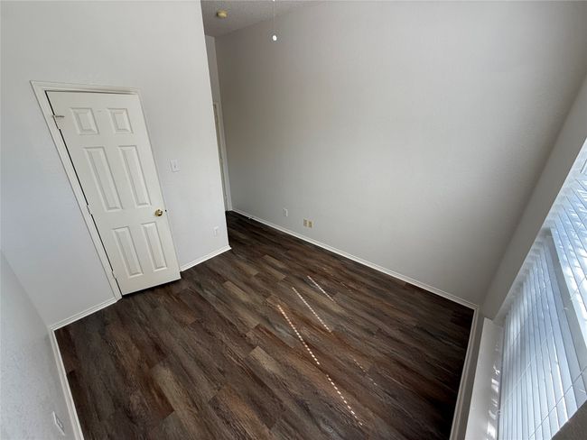 Unfurnished bedroom with dark wood-type flooring and baseboards | Image 19