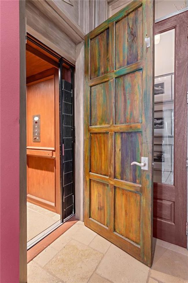 Elevator access on the main floor is beautiflly hidden behind the imported wood door making the transition seamless. | Image 30