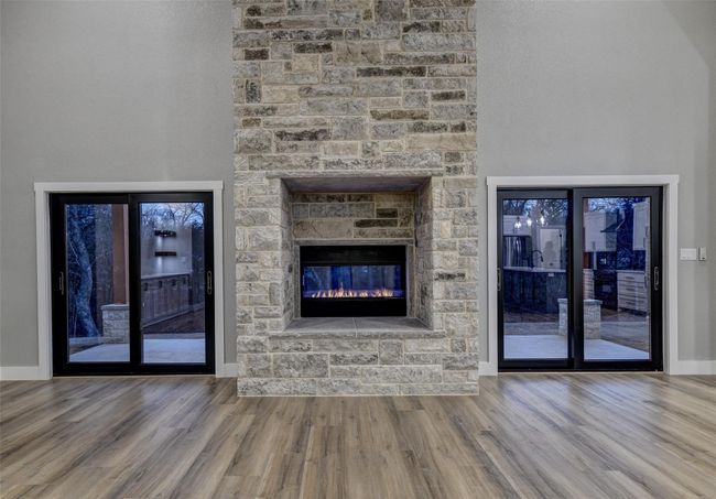 Unfurnished living room with wood-type flooring and a stone fireplace | Image 18