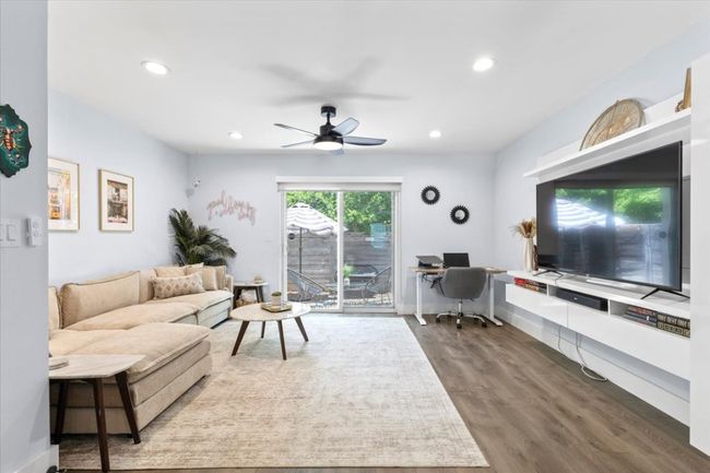 Living area with an office area, wood finished floors, ceiling fan, and recessed lighting | Image 11