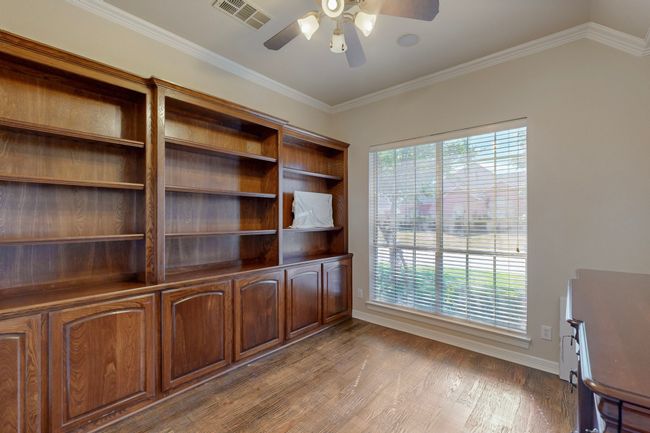 Unfurnished office featuring wood finished floors, ceiling fan, baseboards, ornamental molding, and visible vents | Image 12