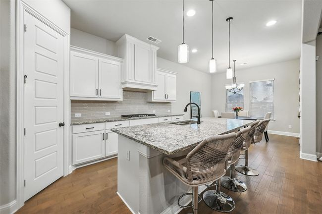 Kitchen with gas stovetop, dark wood finished floors, white cabinets, and recessed lighting | Image 16
