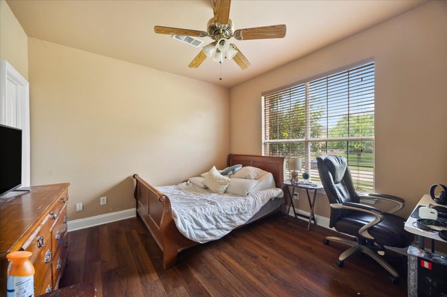 Bedroom featuring baseboards, dark wood-style flooring, a desk, and a ceiling fan | Image 8