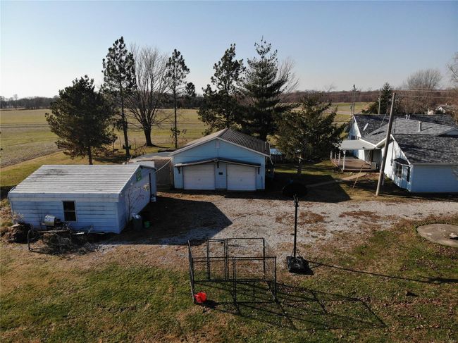 View of yard featuring a garage, a rural view, and an outdoor structure | Image 6