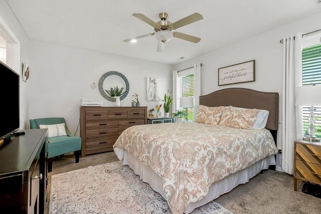 Bedroom with ceiling fan, light carpet, and multiple windows | Image 16