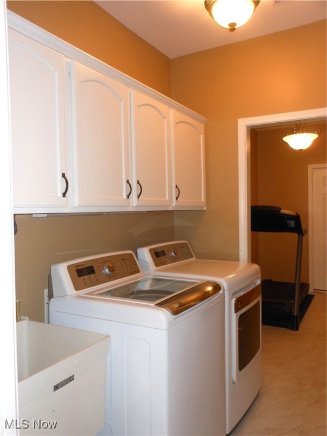 1st Flr Laundry featuring independent washer and dryer, cabinet space & sink. | Image 16