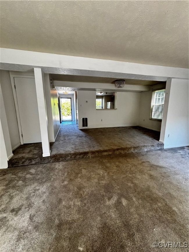 Unfurnished family room with dark carpet and a textured ceiling | Image 6