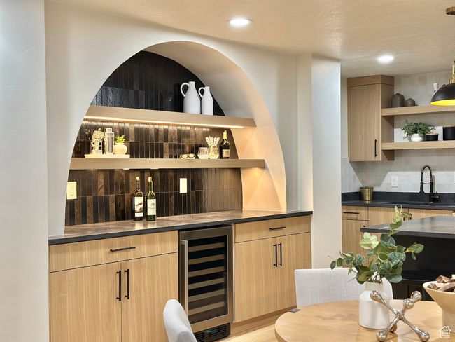 Indoor wet bar featuring wine cooler, backsplash, recessed lighting, and light wood finished floors | Image 29