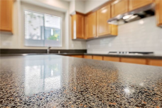 Kitchen view of cooktop and dark stone countertops | Image 21