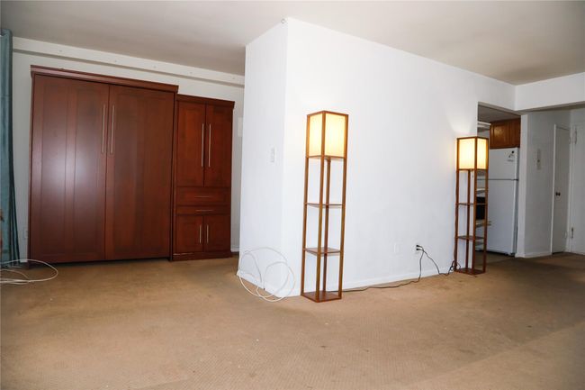 Unfurnished bedroom with freestanding refrigerator and light colored carpet | Image 7