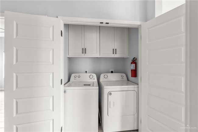 Laundry area featuring cabinet space and washer and clothes dryer | Image 8
