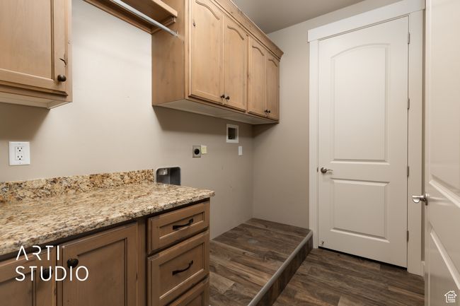 Laundry room with electric dryer hookup, washer hookup, dark wood-type flooring, and cabinet space | Image 12