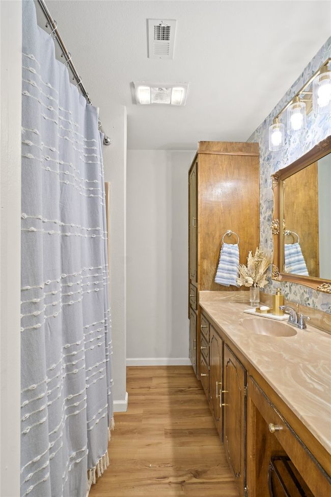 Full bath featuring vanity, wood finished floors, and curtained shower | Image 22