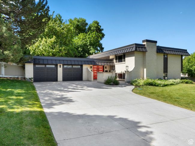 View of front of property with an attached garage, brick siding, concrete driveway, and a front lawn | Image 45