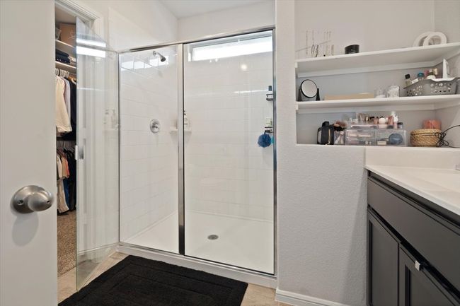 Full bath featuring a shower stall, a walk in closet, and vanity | Image 24