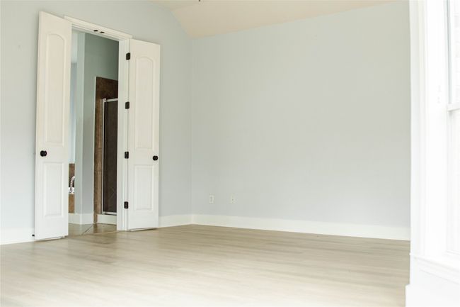 Spare room with light wood-type flooring and lofted ceiling | Image 25
