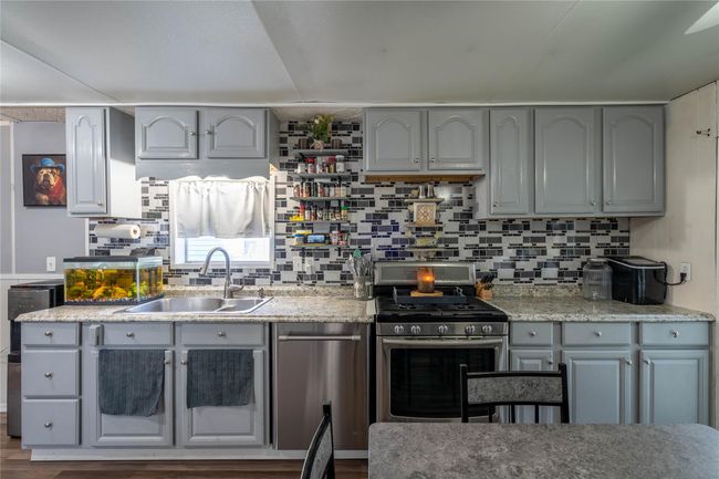Kitchen with gray cabinetry, stainless steel range with gas stovetop, and a sink | Image 6