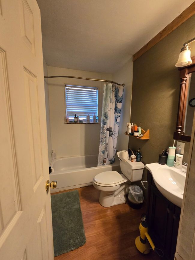Full bathroom with wood finished floors, vanity, and shower / bathtub combination with curtain | Image 26